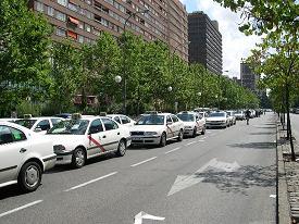 In Madrid taxis are identifiable by their red stripe.